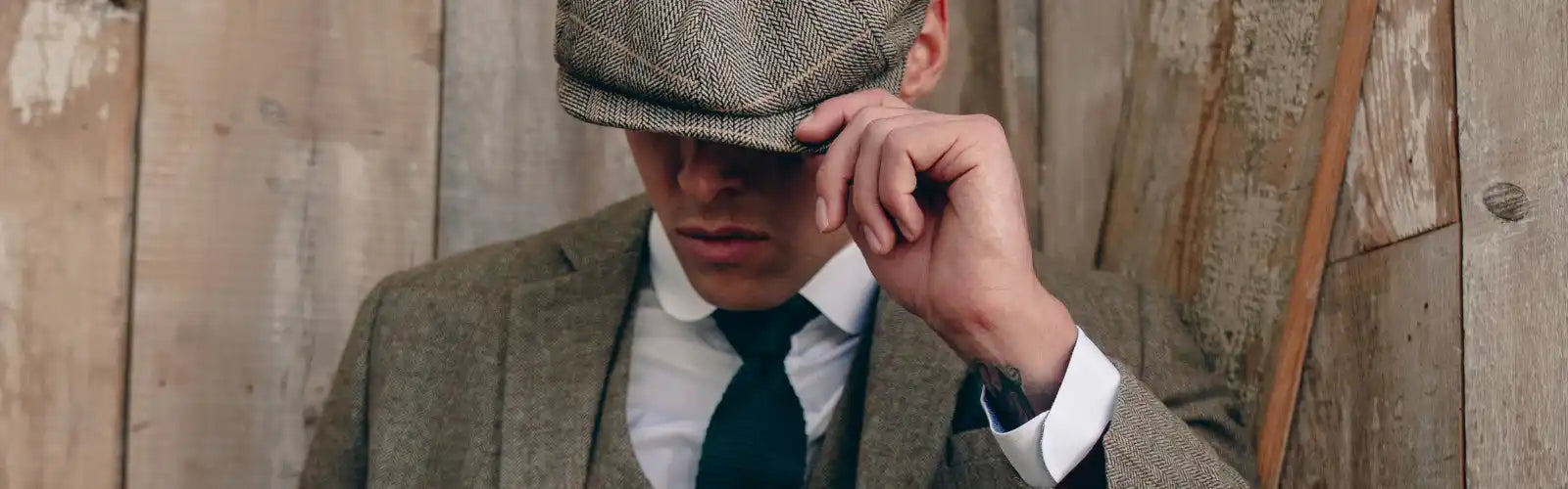 Schirmmütze aus olivgrünem Tweed, getragen mit Anzug und Krawatte.